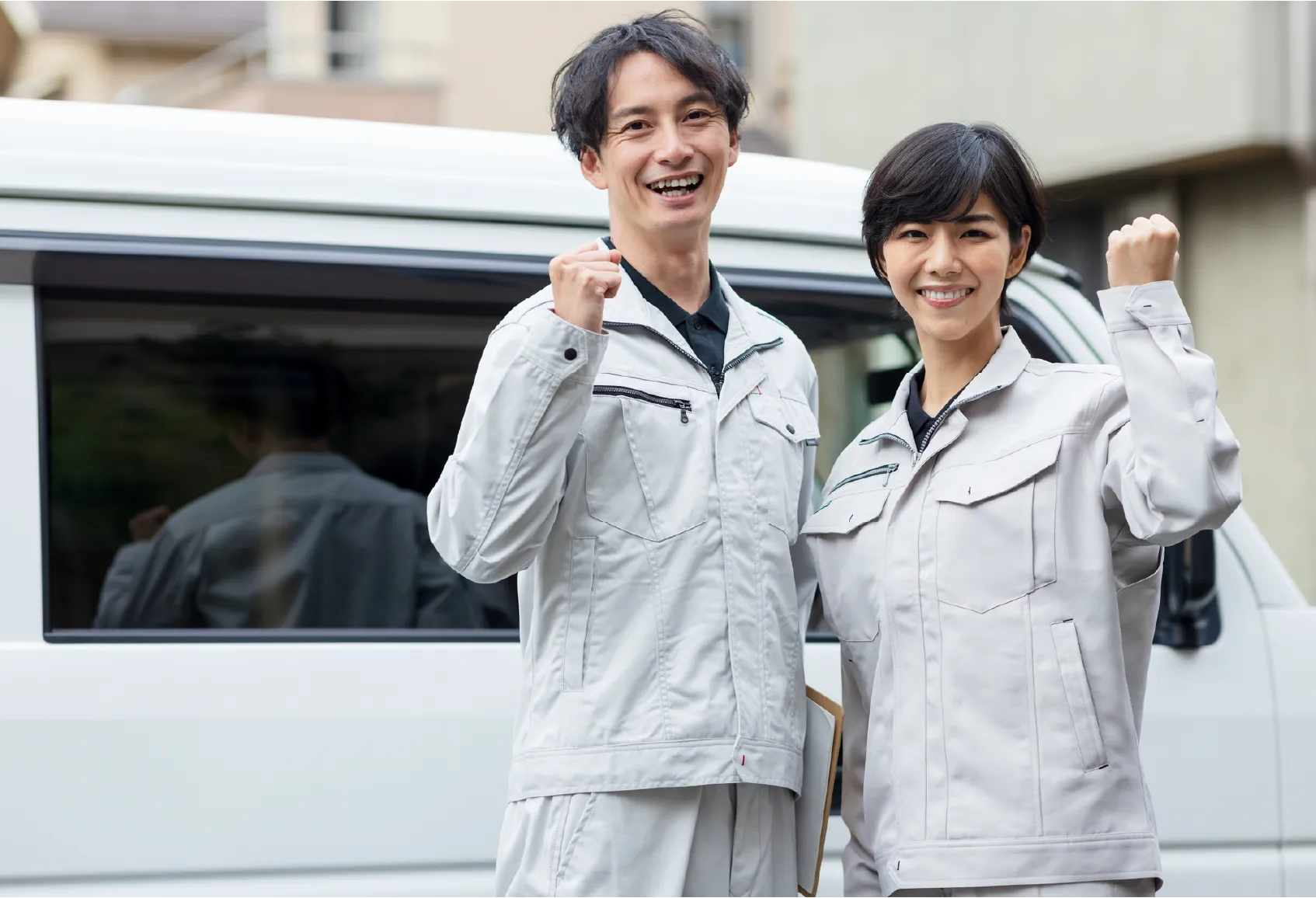 スタッフが作業車の前で笑顔を見せる様子