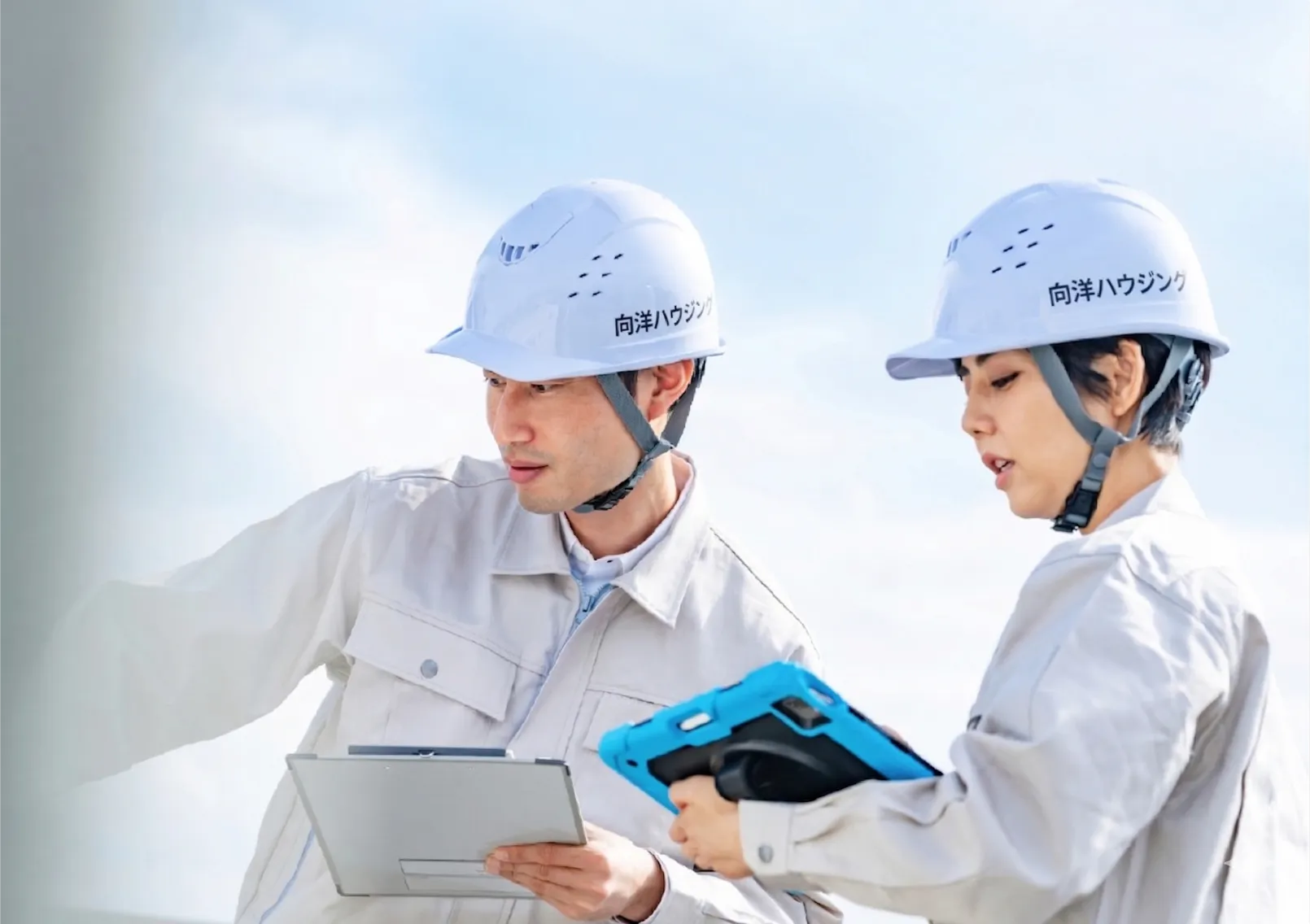 工事現場でヘルメットを着用し打ち合わせするスタッフ