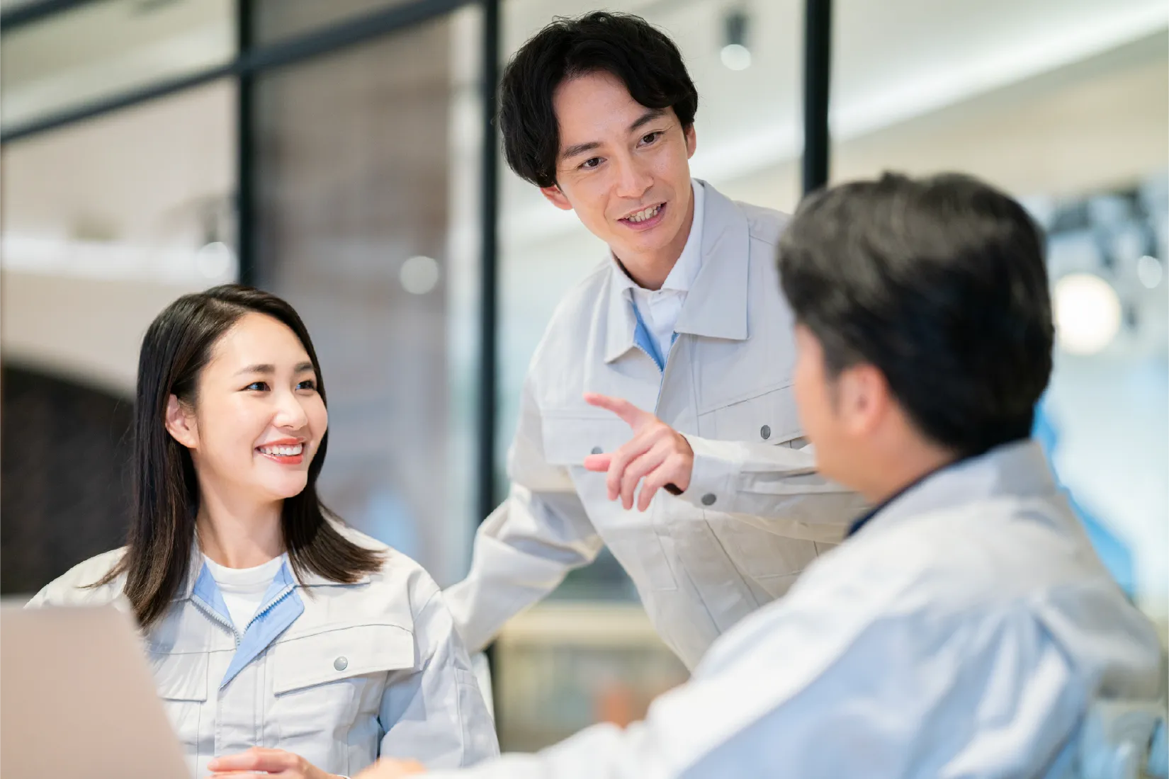 作業服のスタッフが打ち合わせをしている様子