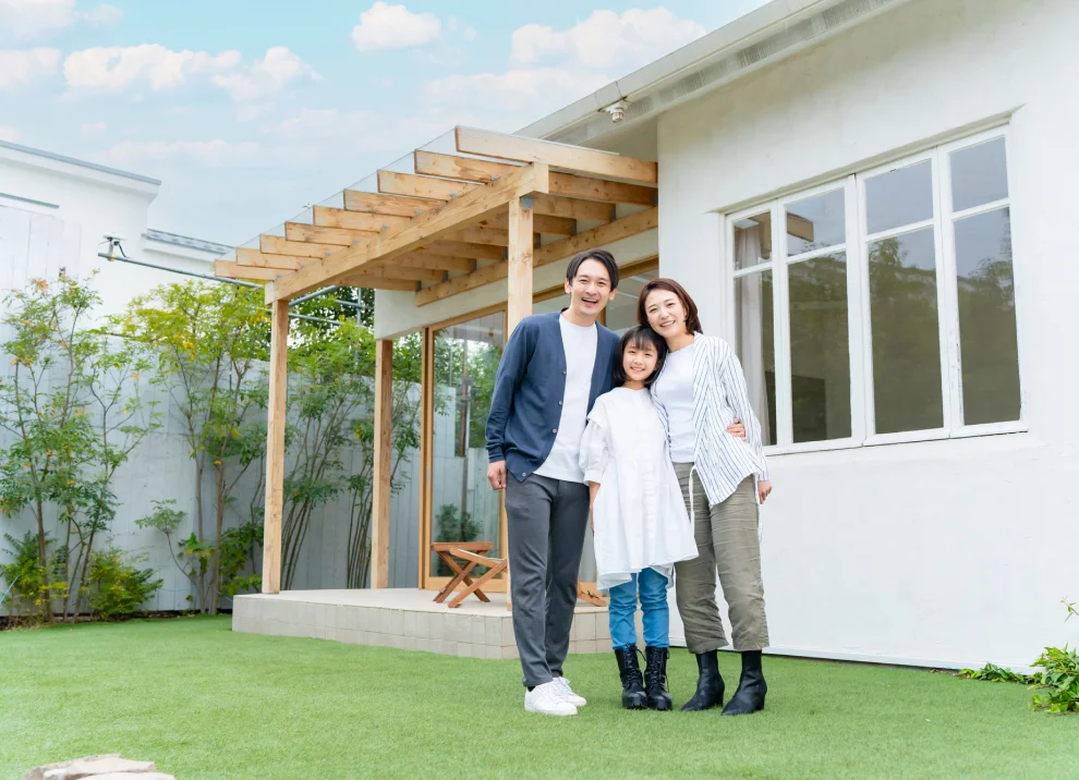 住まいの前で記念撮影する家族の様子