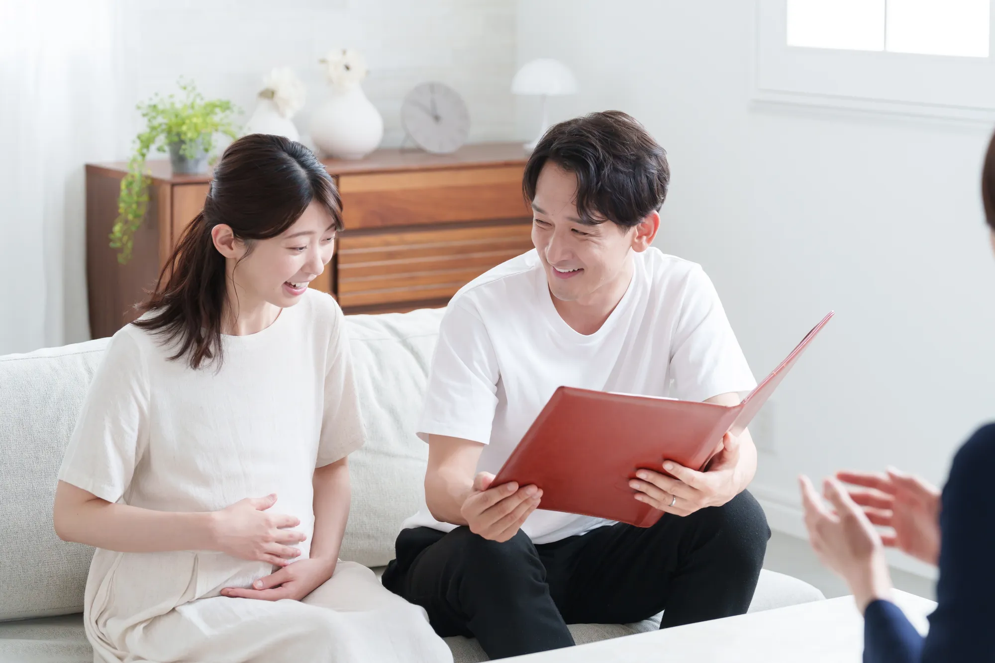 妊婦さんとその夫が理想の住まいについて相談する様子