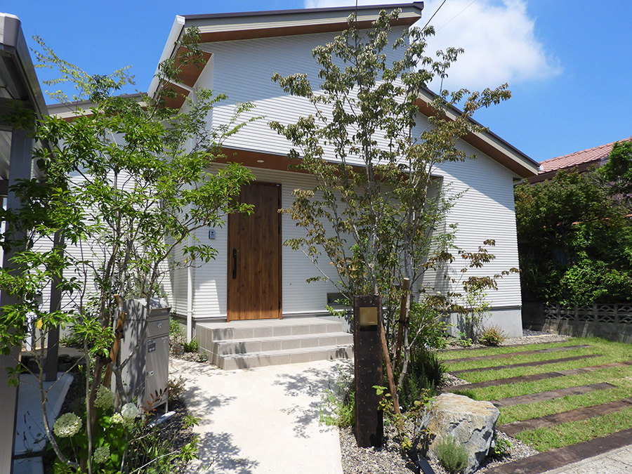 緑の小路。印象的な植栽のアプローチが迎えるワンフロアの住まい。